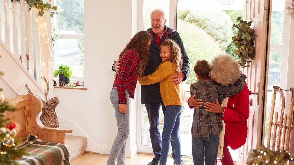 Grandchildren greeting grandparents with presents - stock photo