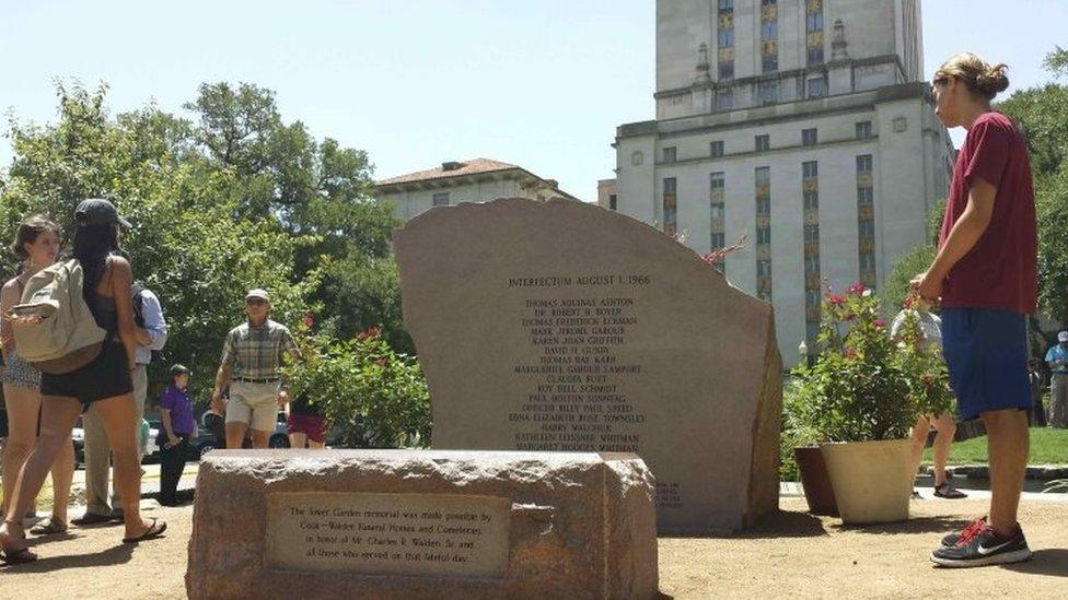 People stand at a monument bearing the names of those killed in the 1 August 1966 University of Texas tower shooting that left 16 people dead, during a memorial in Austin, Texas (01 August 2016)