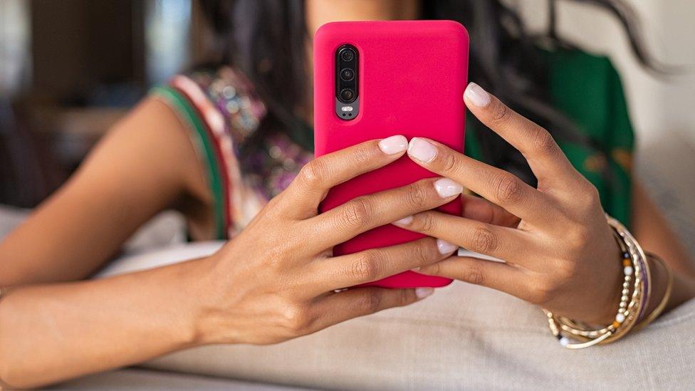 Representational image: A woman holding a mobile phone.