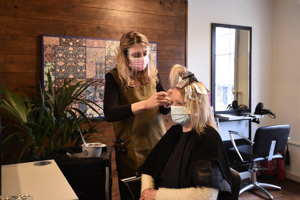 A customer receives a haircut in a salon