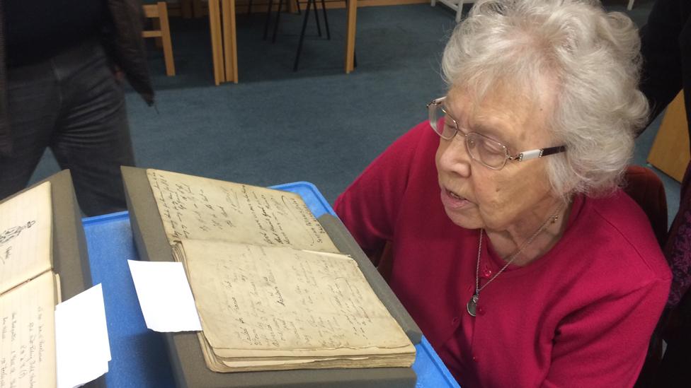 Margery Harrison views the visitors' book