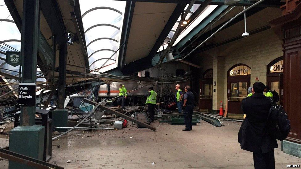 Rail personnel look at the train which breached the station concourse, bringing down part of the roof, on 29 September 2016