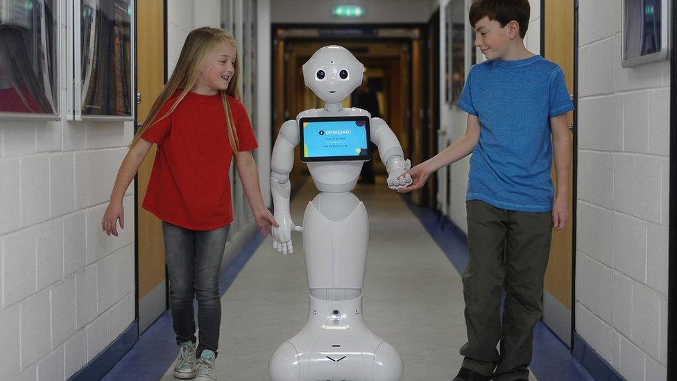 two-children-walking-down-corridor-with-roboto