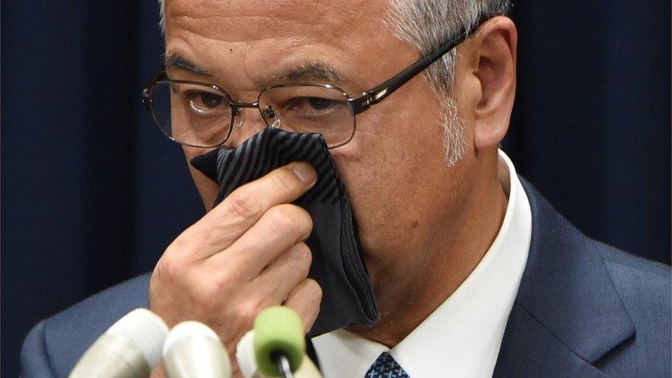 Japan"s Economy Minister Akira Amari wipes his nose during a press conference in Tokyo on January 28, 2016.