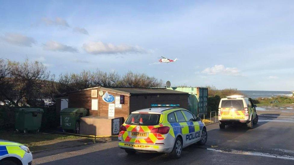 Police cars and coastguard helicopter