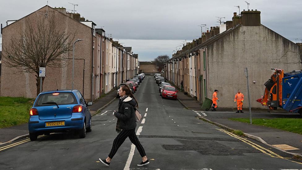 Refuse collectors work on a street in Workington, on 6 November 2019