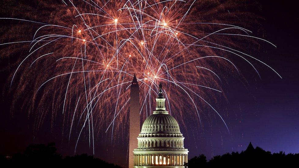 Fireworks pictured exploding in bright streaks behind US Capitol and Washington Monument