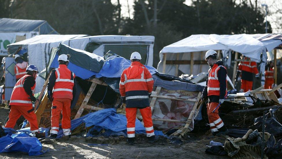 Workers demolish a shelter in the migrant camp, the "Jungle", in Calais, France, 2 March 2016