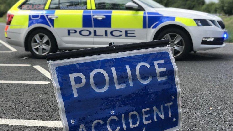 A police car parked next to a sign that reads: POLICE - ACCIDENT