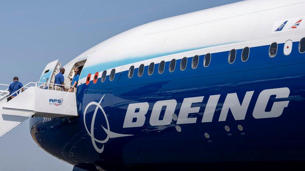 Visitors climb steps to take a tour of a Boeing 777X jet airliner at the Farnborough Airshow.