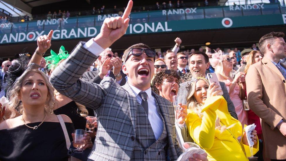 People celebrate the end of a race at Aintree