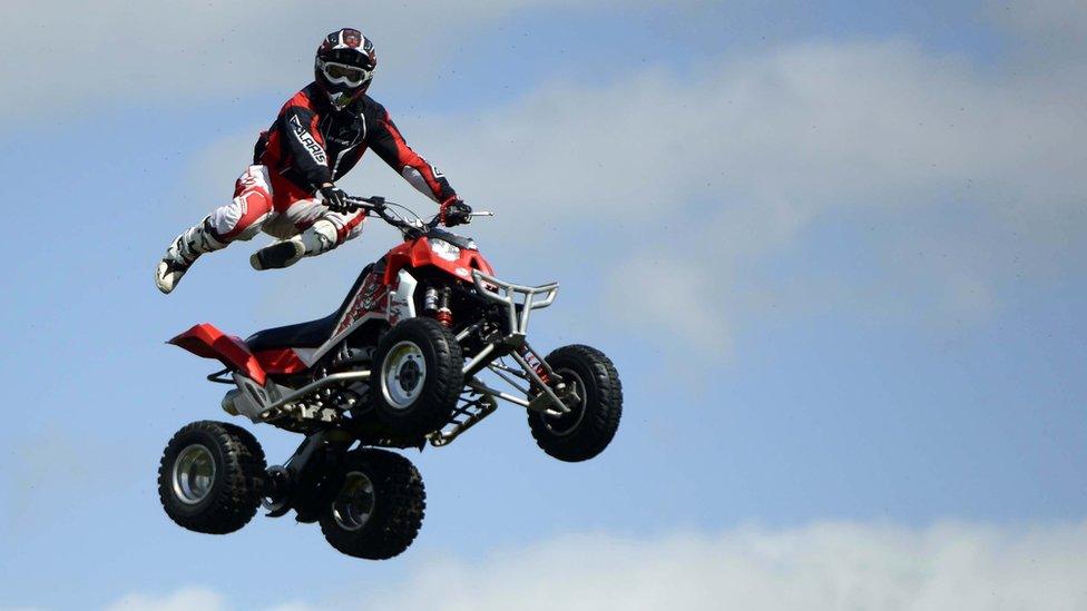 A quad bike rider does a stunt at Balmoral Show