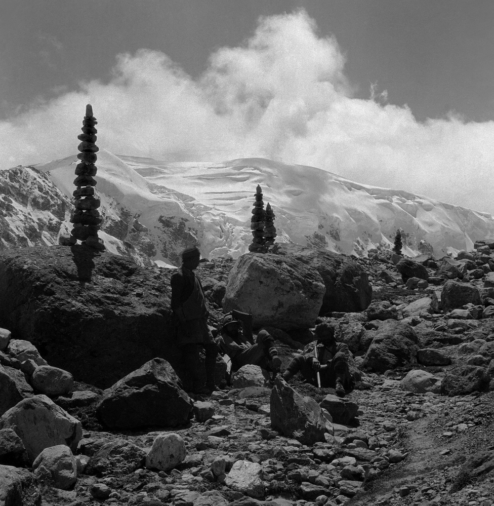 A black and white picture showing cairns at a rest stop on the way up to the Kharta Glacier