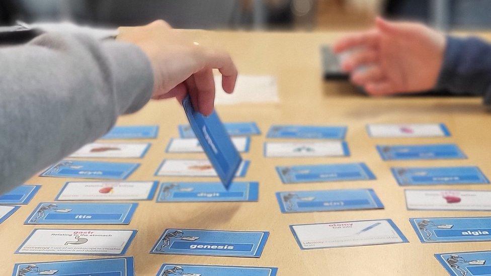 Playing cards on table with hands