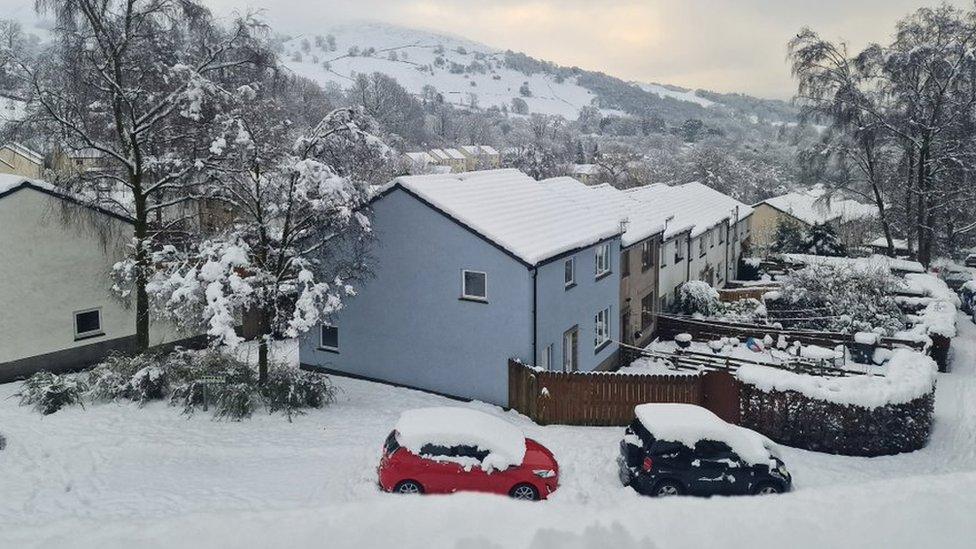 Snow on houses and cars in Ambleside