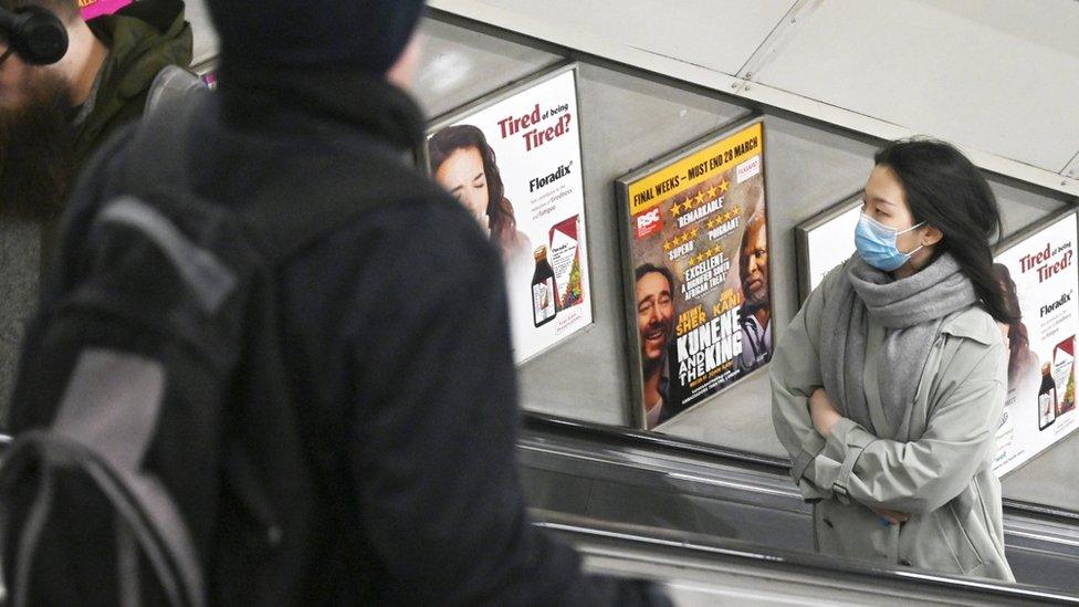 Woman wearing mask on escalator