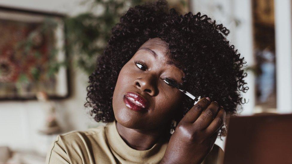 Woman putting mascara on