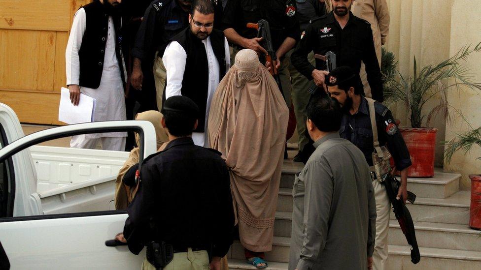 Policemen escort Sharbat Gula (C) as she leaves after appearing before a court in Peshawar, Pakistan, November 4, 2016