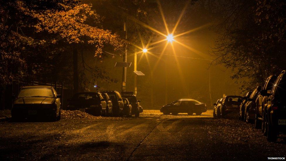 Cars parked in the dark under a streetlight