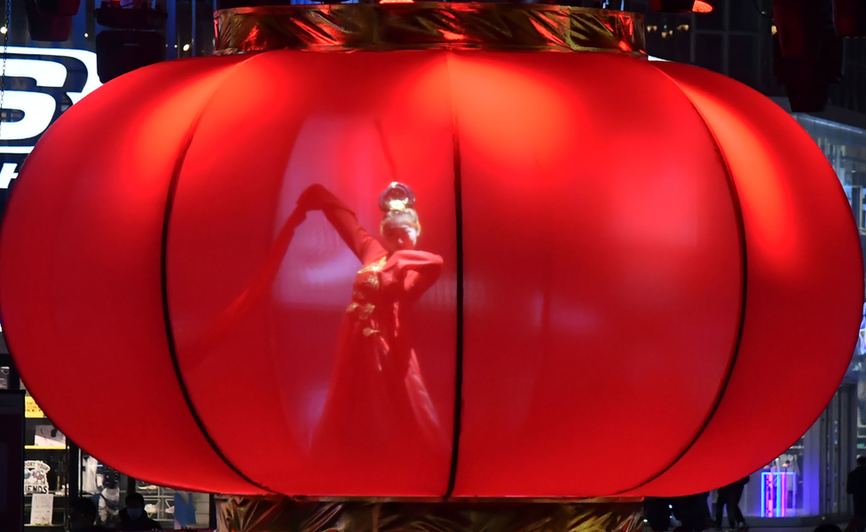 A woman dances inside a huge red lantern in Shenyang, north-eastern Liaoning province. Photo: 26 February 2021