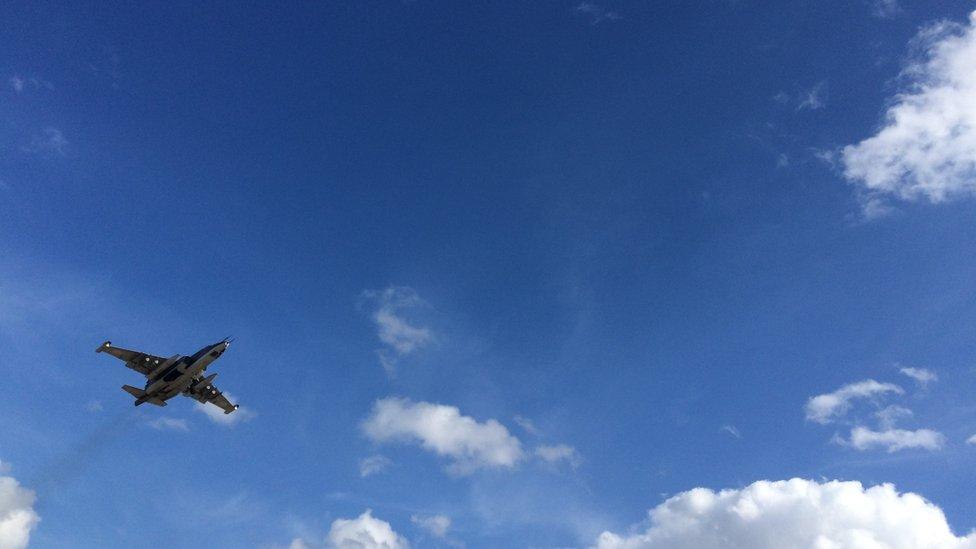 A fighter jet flies overhead