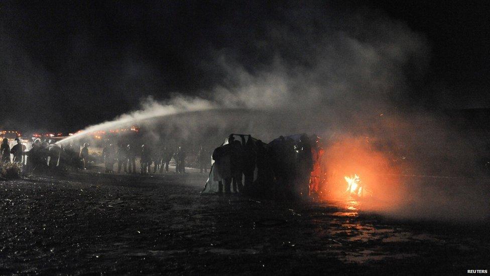 This is a photo of police using a water cannon to put out a fire started by protesters.