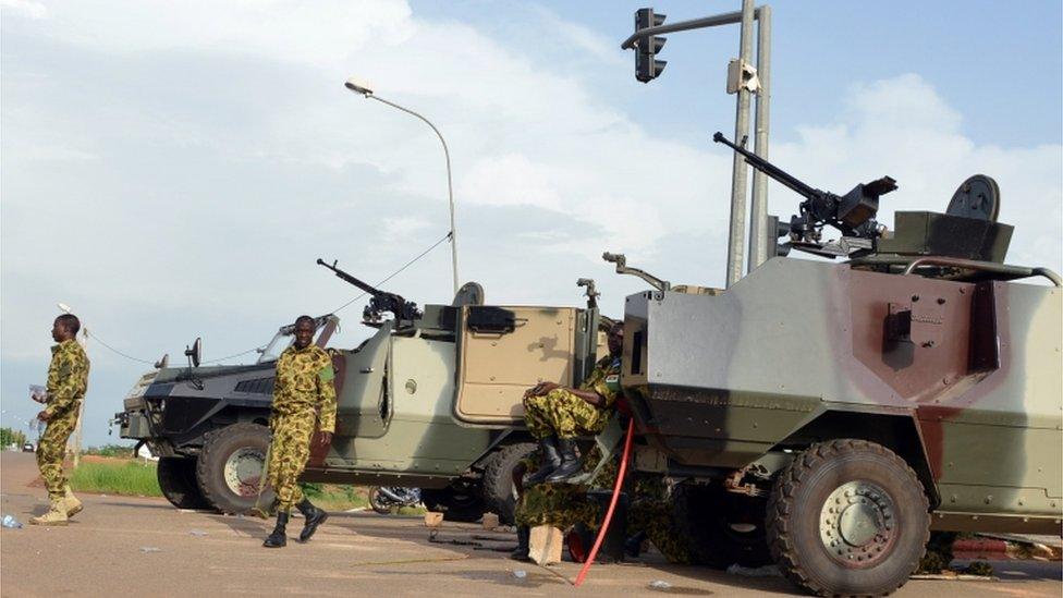 Troops stand next to vehicles on September 17, 2015 outside the presidential palace in Ouagadougou