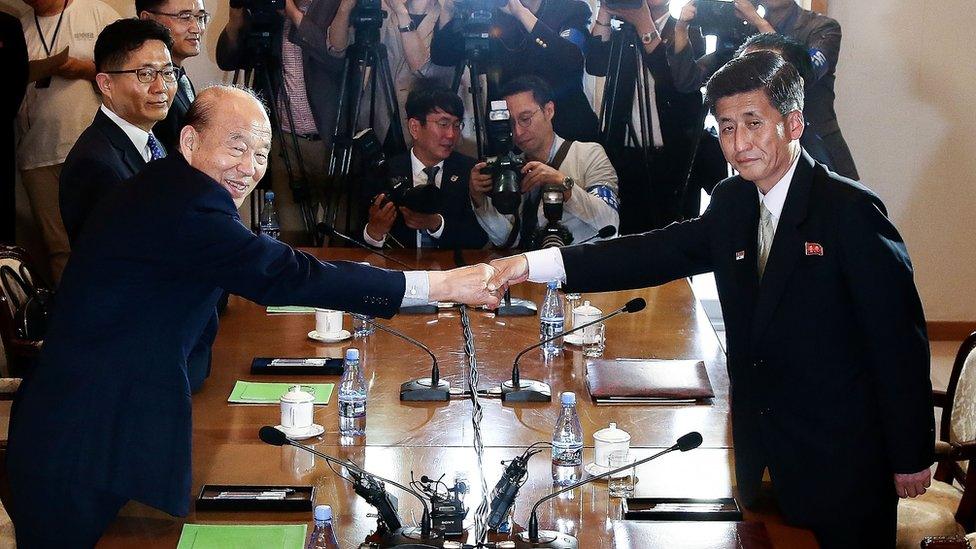 South Korean Park Kyung-seo (L) head of the Korean Red Cross, shakes hands with Pak Yong-il (R) vice chairman of the Committee for the Peaceful Reunification