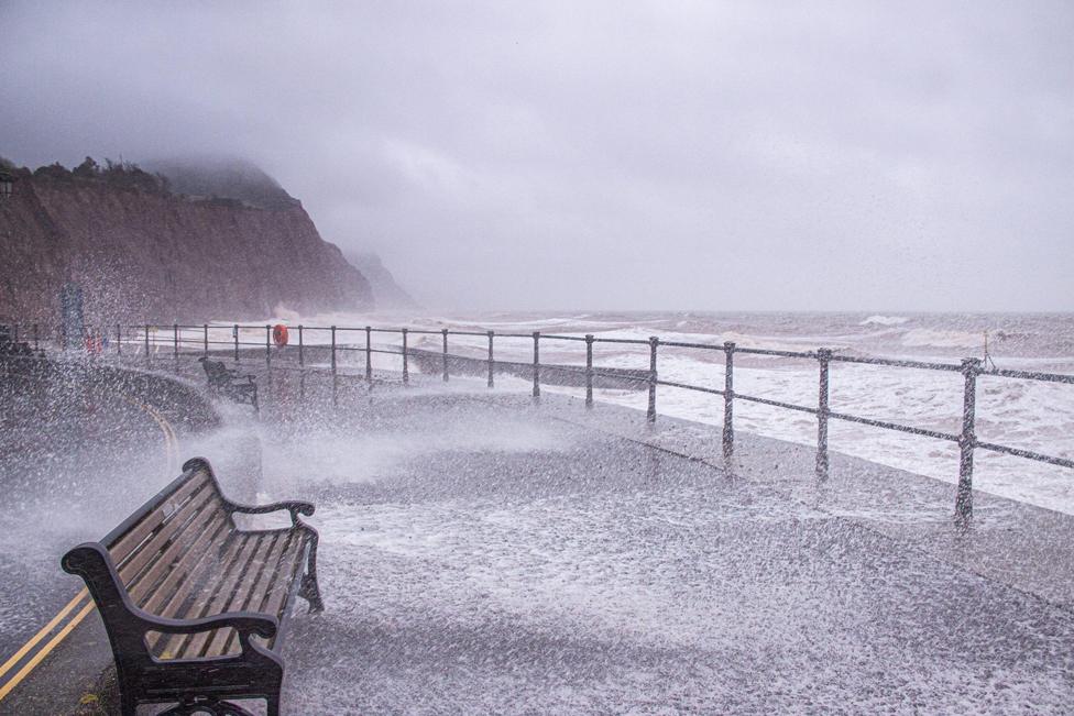 The sea bursts on to a deserted esplanade at Sidmouth, Devon