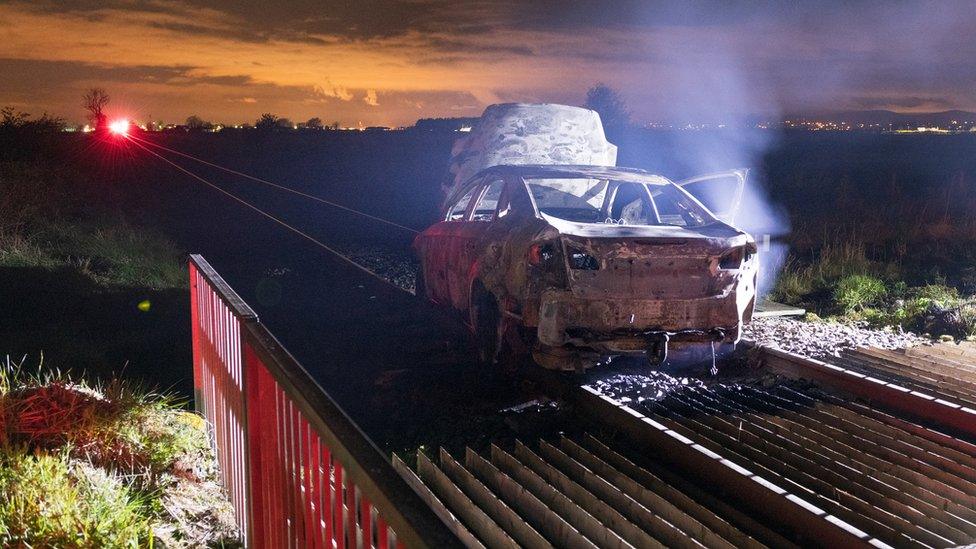 burned car on railway track