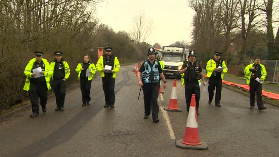 Police officers approach protesters on London Road in Wellingborough