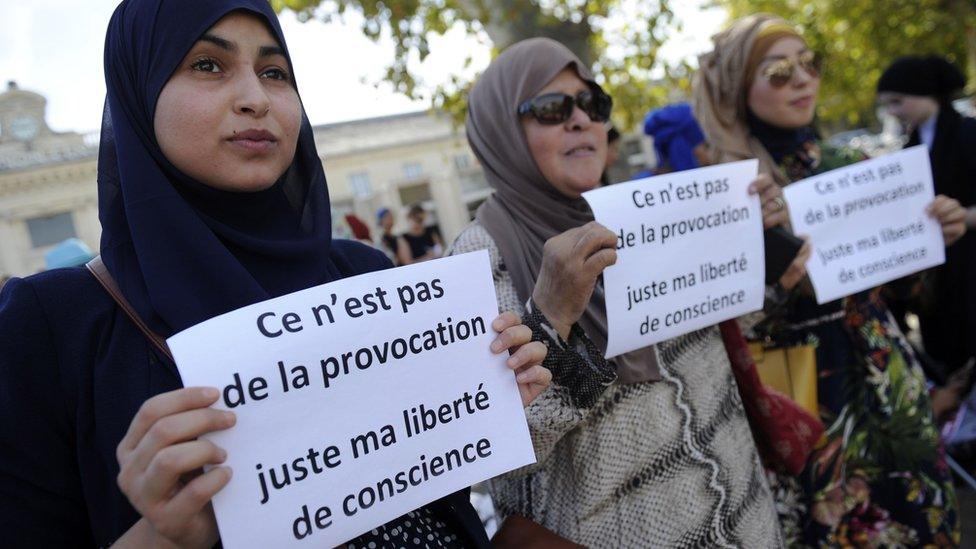 Women hold signs reading "Is it not a provocation, just my freedom of conscience" during a "headscarf march" in Avignon