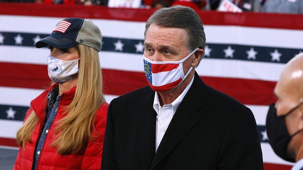 Republican Senators David Perdue and Kelly Loeffler look on ahead of U.S. President Donald Trump hosting a campaign event