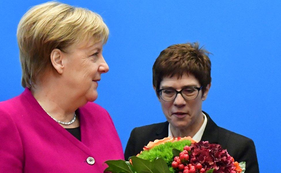 German Chancellor and leader of the Christian Democratic Union (CDU) Angela Merkel (L) receives flowers next to CDU's Secretary General Annegret Kramp-Karrenbauer before a CDU leadership meeting at the party's headquarters on October 29, 2018 in Berlin