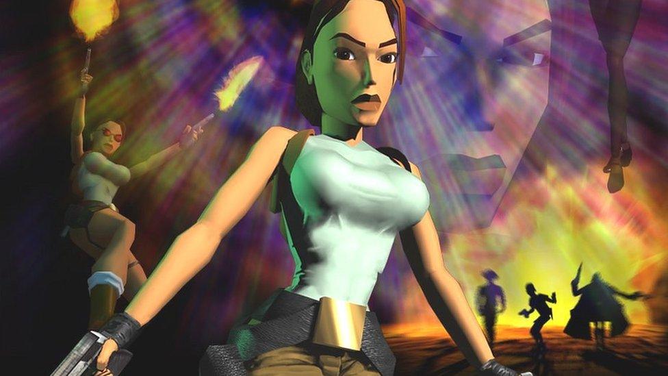 Lara Croft. Lara is a very blocky animation with brown hair, brown eyes, a blue crop top and exaggerated breasts. She holds a gun and wears a large utility belt.