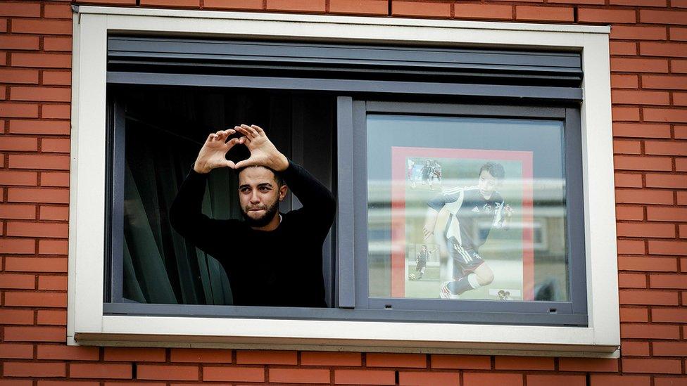 The brother of Abdelhak Nouri, Mohammed, forms a heart gesture from a window of the house of Abdelhak Nouri in Amsterdam, the Netherlands, 14 July 2017