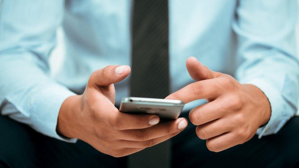 Generic photo of a man looking at a mobile phone