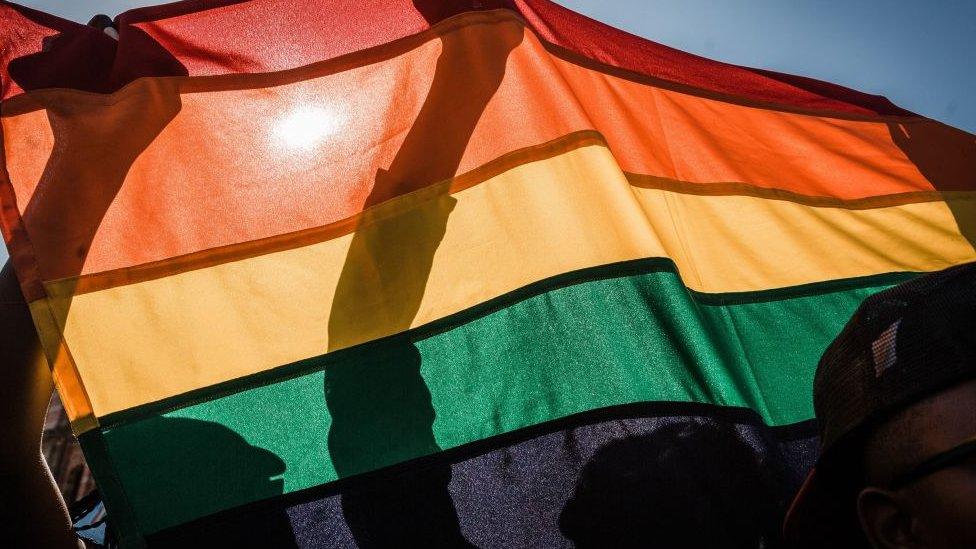 People with a rainbow flag take part in the annual Gay Pride Parade, as part of the three-day Durban Pride Festival, on June 30, 2018 in Durban.