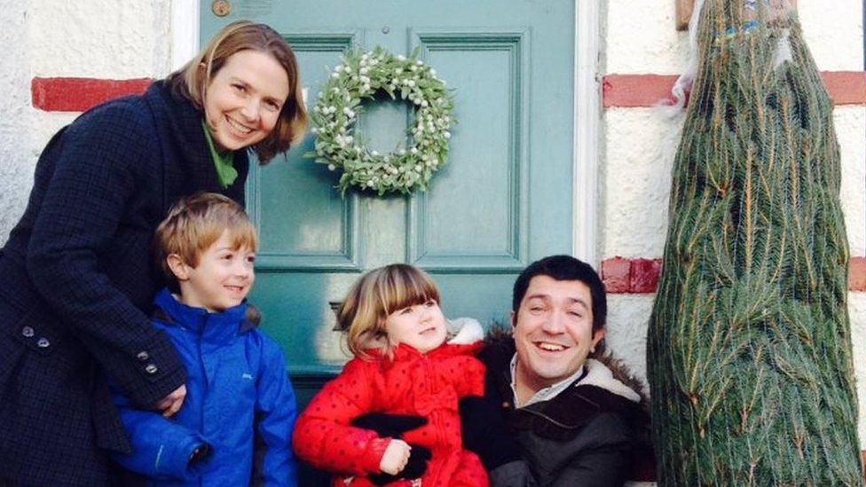 The Wilsons outside their front door with a Christmas tree