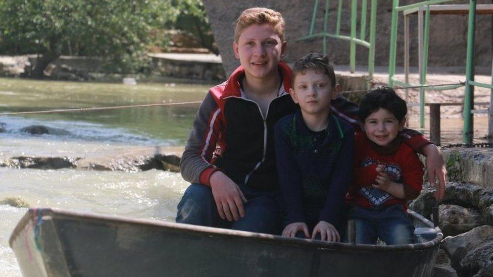 Three of Hiba's brothers in a boat