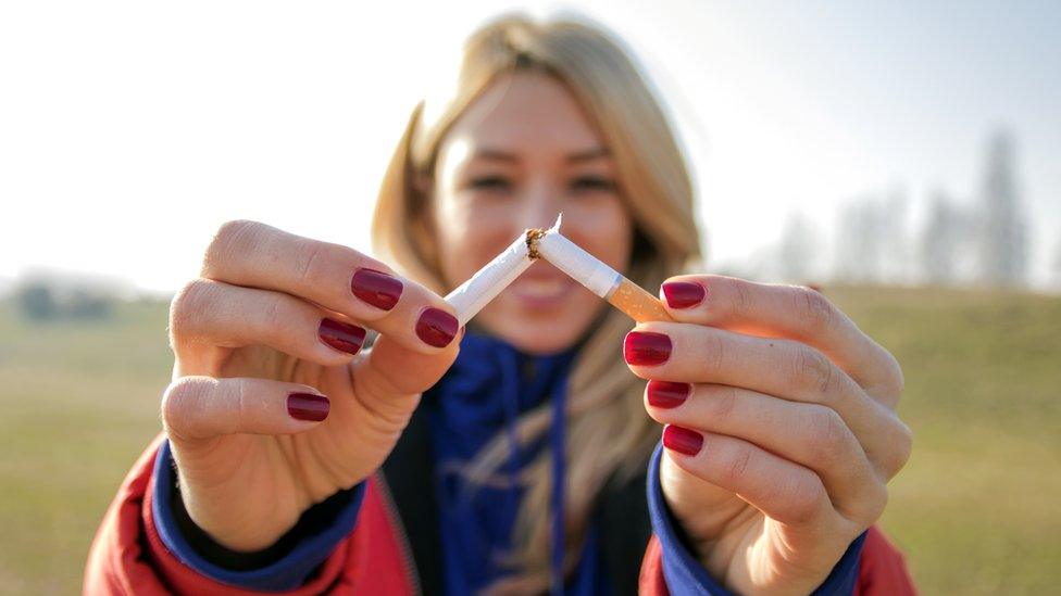 Young woman breaking a cigarette