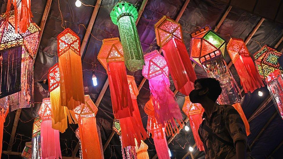 A man looks at lanterns hanging at a lantern market in Mumbai city