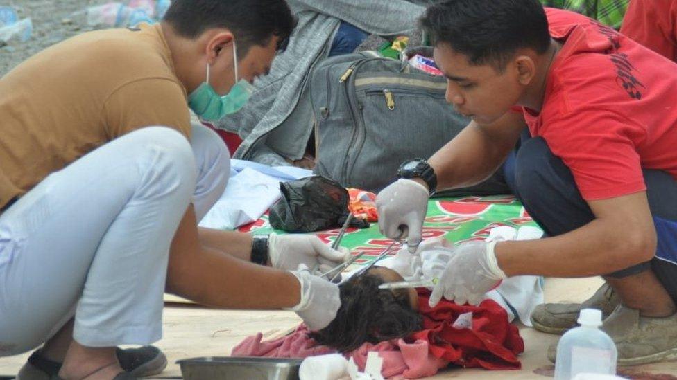 Medics treat a wounded child in Palu. Photo: 29 September 2018