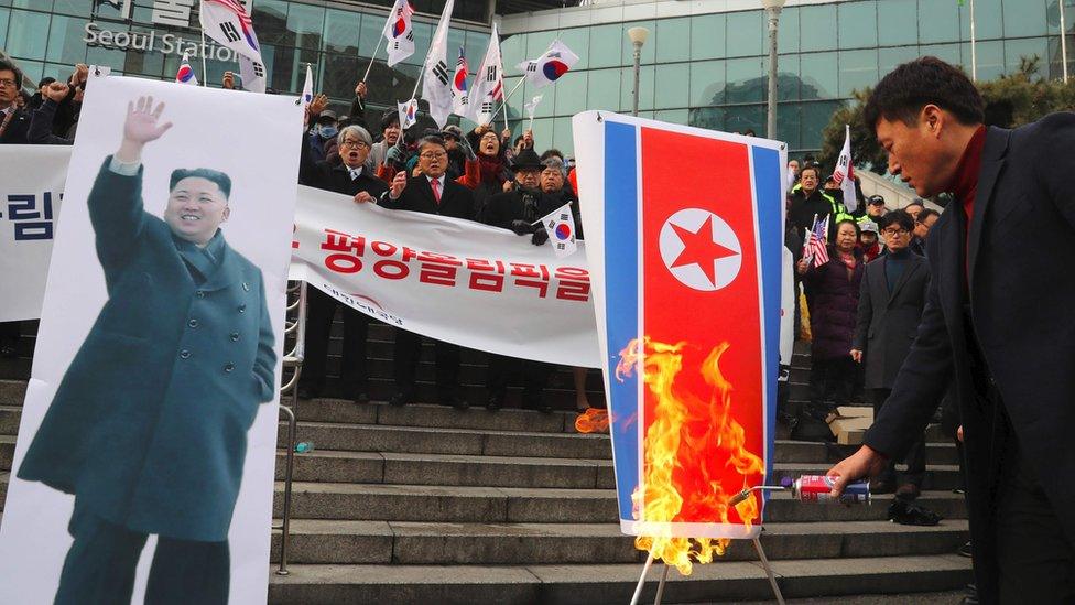 South Korean protesters burn a North Korean flag (R) and a picture (L) of North Korean leader Kim Jong-Un during an anti-North Korea rally