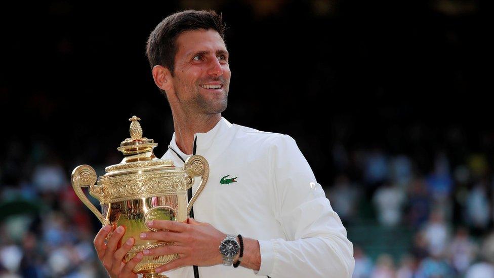 Serbia's Novak Djokovic with the trophy as he celebrates winning the final against Switzerland's Roger Federer