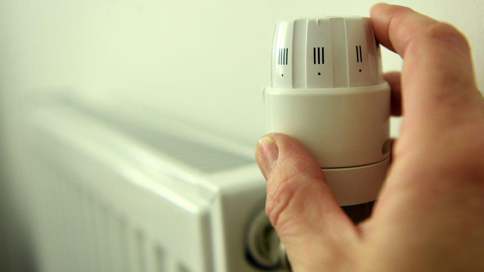 Hand changing dial on radiator