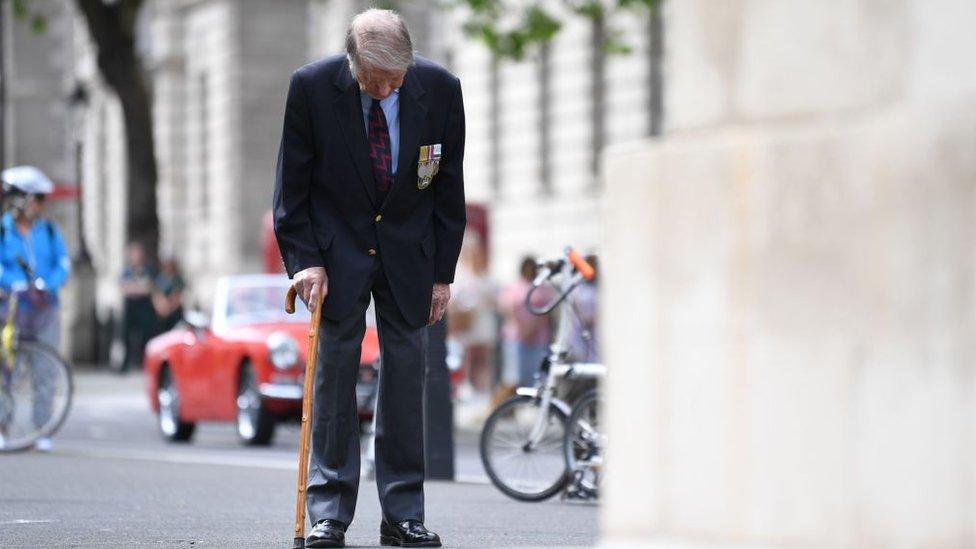 Veteran Lou Myers, 93 bows his head at the Cenotaph as he takes part in the two-minute silence on 8 May 2020