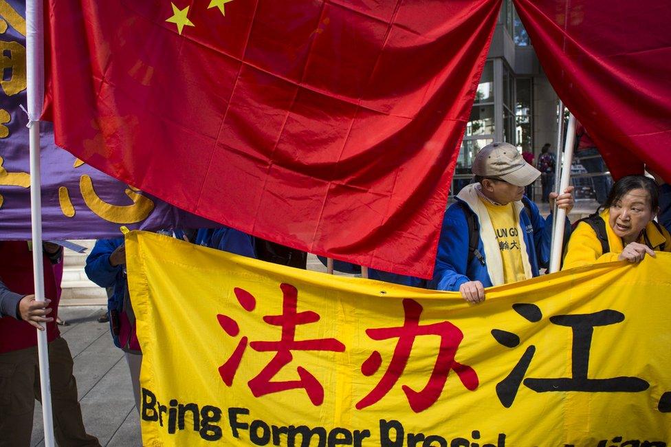 Practitioners of Falun Gong, who say the religious movement is persecuted in China, protest the visit of Chinese President Xi Jinping as counter-protestors cover their signs with Chinese flags in Seattle, Washington, 22 September 2015