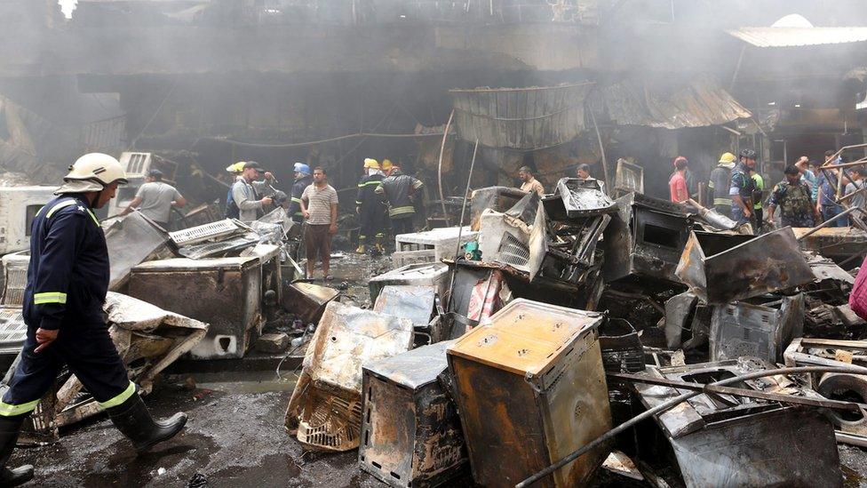 Iraqi fire-fighters check the site of a car bomb attack in Baghdad on 9 June