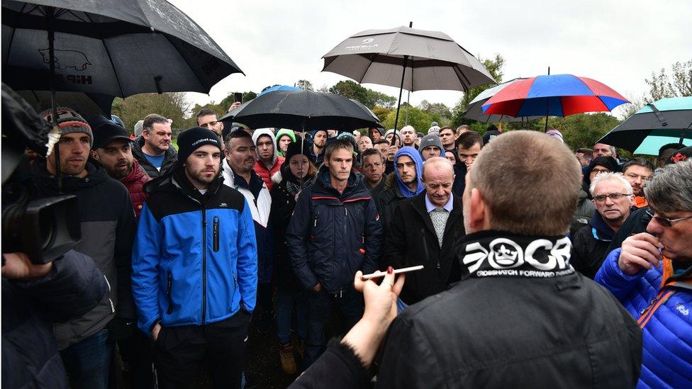 Former Wrightbus employees wait outside the factory for news on talks to sell the company